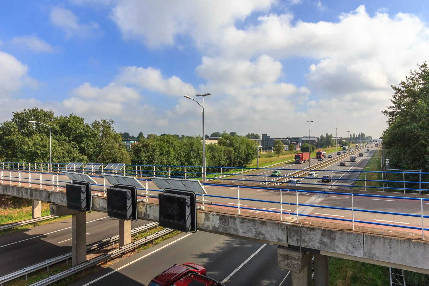 Verkeer op snelweg A2 bij De Welle gezien vanaf een viaduct met zonnepanelen en matrixborden.